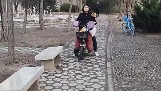 What does it look like when a Moroccan bride practices riding an electric scooter  using chopsticks?