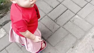 baby girl in red is learning to walk