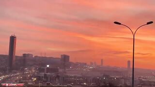 Highway Traffic at Sunset with City Skyline