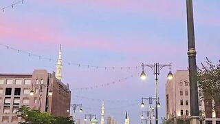 Pedestrian Walking on City Sidewalk at Sunset