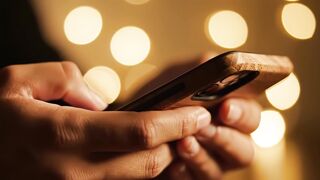 Smartphone usage video footage with warm bokeh background light effects