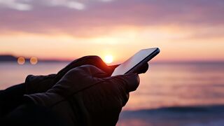 Smartphone held by gloved hands during beautiful sunset motion video