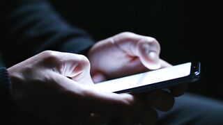 Smartphone screen interaction in dark room motion video footage clip