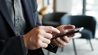 Smartphone screen interaction by professional businessman in modern office video footage