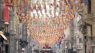 Travelon - a street with people walking and hanging flags | Trending HD Video