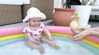 Baby Meets a Duckling in the Pool.