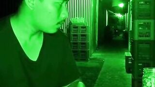 Man Counting Money in Dark Alleyway under Green Night Vision Camera
