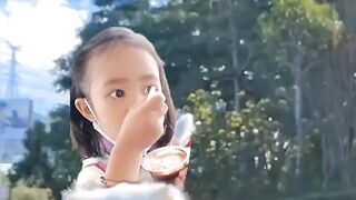 The little girl eating ice cream while seating at the back of a  cat ????