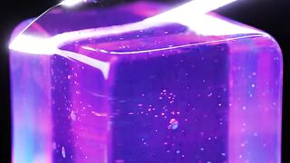 Glowing purple ice cube with laser light reflection on dark reflective surface for futuristic tech concept