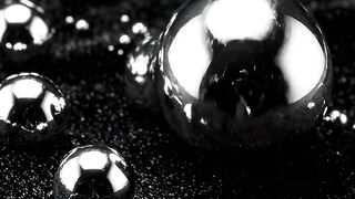 Soccer balls with water droplets on wet artificial turf at night under dramatic lighting