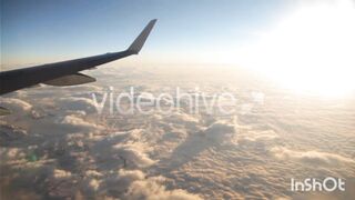 Airplane Wing Soaring Above Clouds at Golden Sunrise