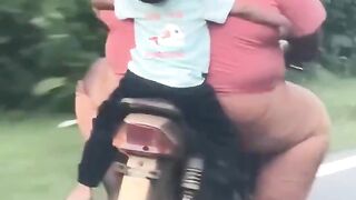 Cute Kid Holding On Tight On The Back Of A Bike