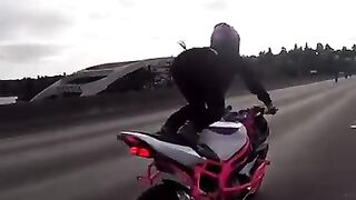 Mulher empinando na moto