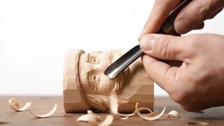 Craftsman carving Santa Claus face in wood