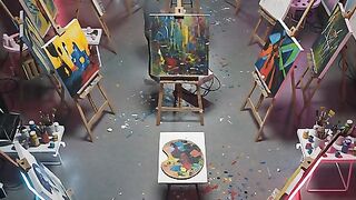 Artist painting in a modern neon art studio with multiple canvases on wooden easels