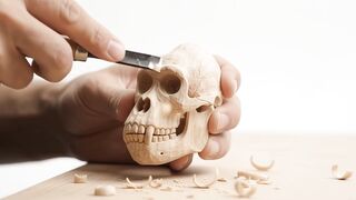 Craftsman carving miniature gorilla skeleton