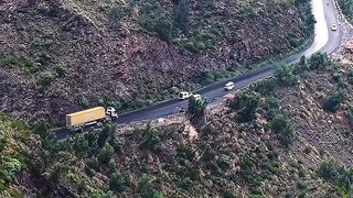 Cars passing on the road between mountains