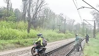 Enduro amador: pilotando uma motocicleta sobre trilhos de trem molhados.