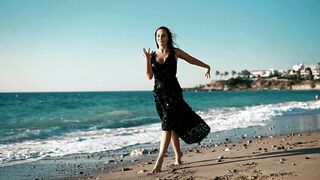 Graceful Young Woman Dancing By The Ocean On A Sunny Summer Beach