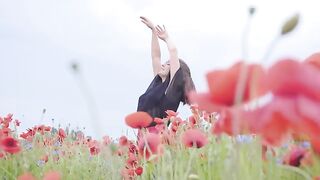 Girl dancing happily in a field of flowers
