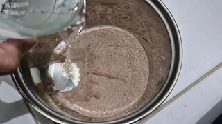 The slow movement of water being poured into chocolate powder.