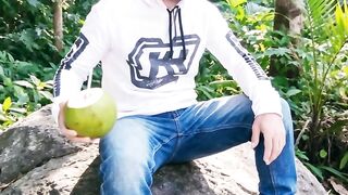 Drinking young coconut water on a rock