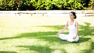 Serene Young Woman Meditating In A Peaceful Summer Garden