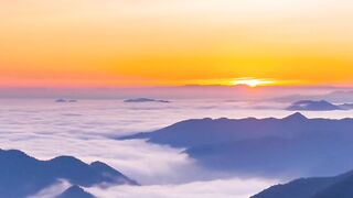 Beautiful Sunrise Over Mountain Peaks Above a Sea of Clouds