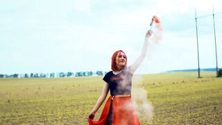 Stylish Woman Creating Vibrant Smoke in Countryside