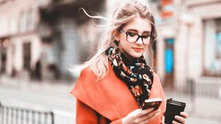 Modern Girl Enjoying Morning Coffee While Using Her Smartphone
