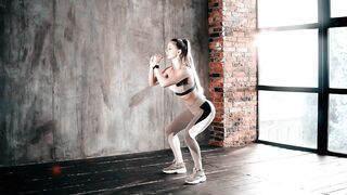 Fit Young Woman Practicing Squats for Strength and Fitness