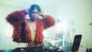 Woman in Headphones Creating an Energetic Techno Music Set
