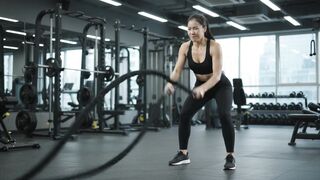 Asian girl wearing black sport ware workout at gym