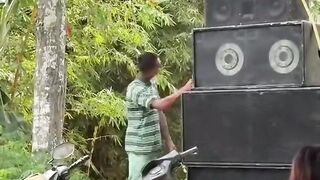 Seorang laki laki berjoget disamping speaker