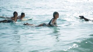 Young Women Surfers Enjoying Summer Surfing Adventure at Sunrise