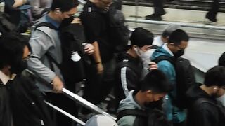 Crowded Passengers Boarding a Commuter Train at a Busy Railway Station