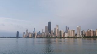 Beautiful twilight view of Chicago skyline reflecting on calm water.