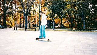 Young Female Skater Enjoying Outdoor Longboarding in the Park