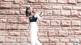 Attractive Girl Enjoying a Fun Music Walk Through the City