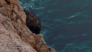 Scenic coastal view with waves crashing against rocks. Ideal for travel videos.