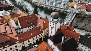 Aerial footage of a European town with red rooftops and a river.