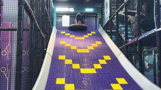Child Sliding Down a Playground Slide on an Inflatable Tube