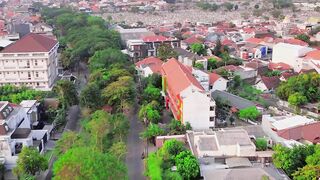 Aerial Drone Footage of Green Housing Areas with City Skyline in Surabaya