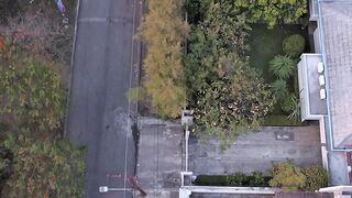 Aerial Top Down View of a Motorcycle on a Quiet Residential Street at Sunset