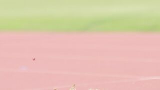 An orange cat is scratching its head on the running track.