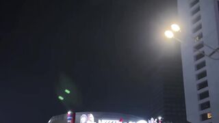 Night cityscape with glowing buildings and moving cars