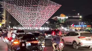 Nighttime traffic flows beneath glowing green signs