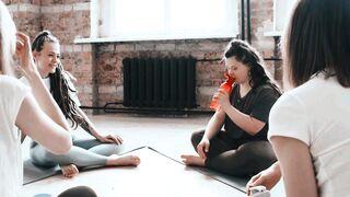 Diverse Women Relaxing and Chatting Together After Yoga Session