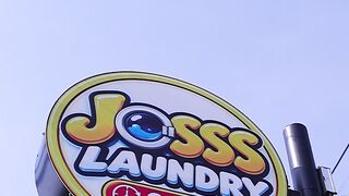 Low Angle View Of Joss Laundry 24 Hour Round Signboard On Pole Against Blue Sky In Surabaya Indonesia