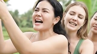 Three beautiful women pull bananas from a tree until they fall.